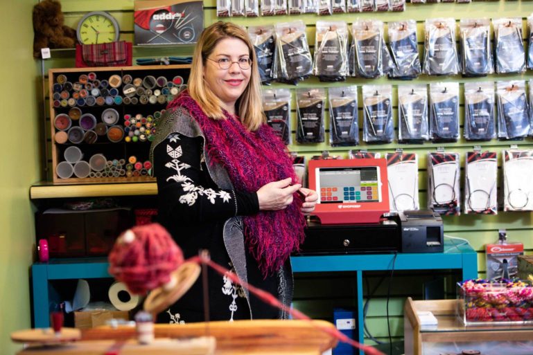 yarn shop owner standing in front of her ShopKeep terminal - how to use an iPad cash register