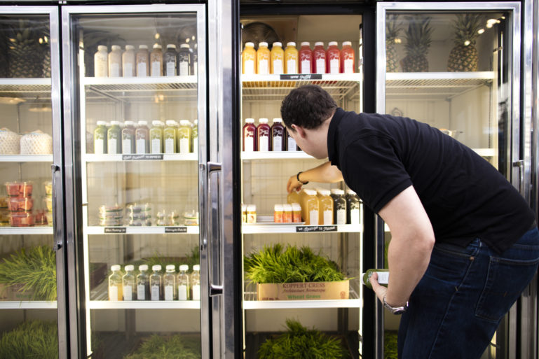 man stocking juice at franchise - difference between franchising and licensing