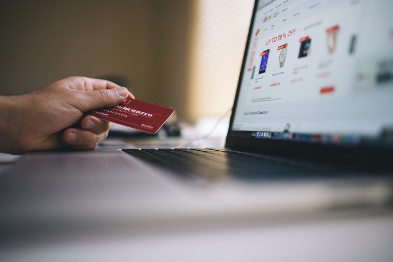 person shopping with credit card online - advantages and disadvantages of ecommerce