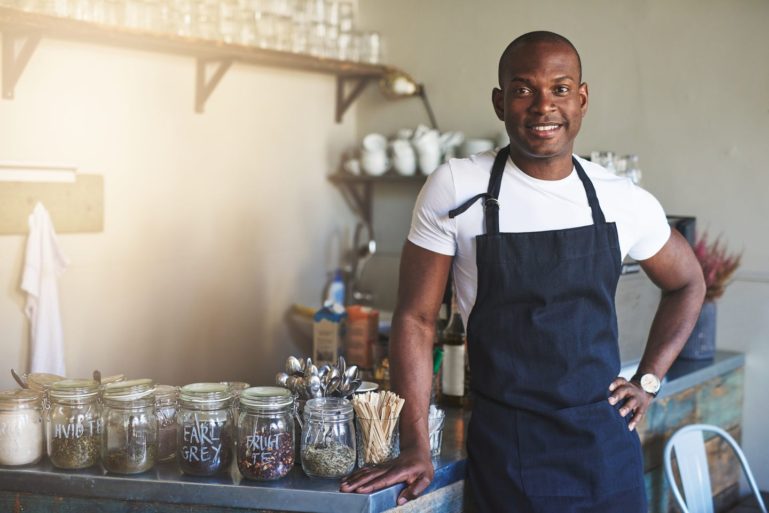 small business owner standing in his shop - advantages of debt financing