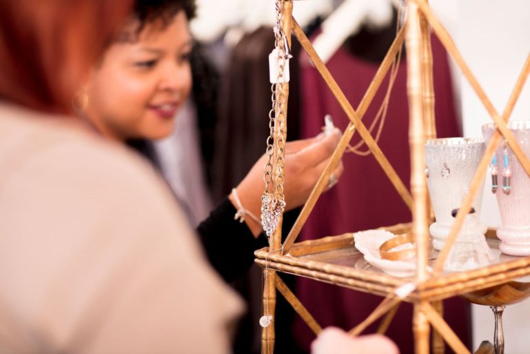 woman looking at necklace - promotion ideas for retail stores