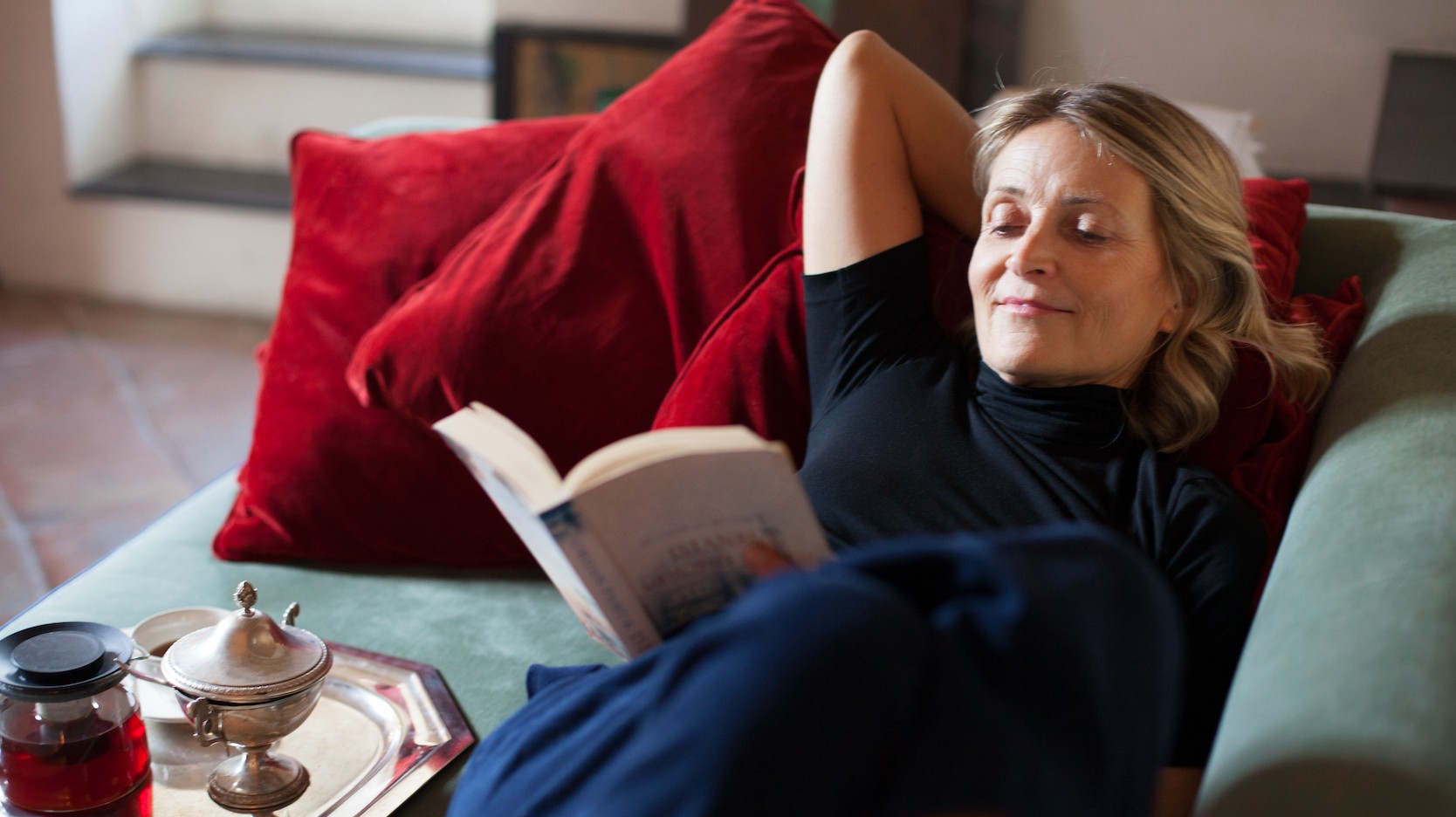 woman reading a book on couch