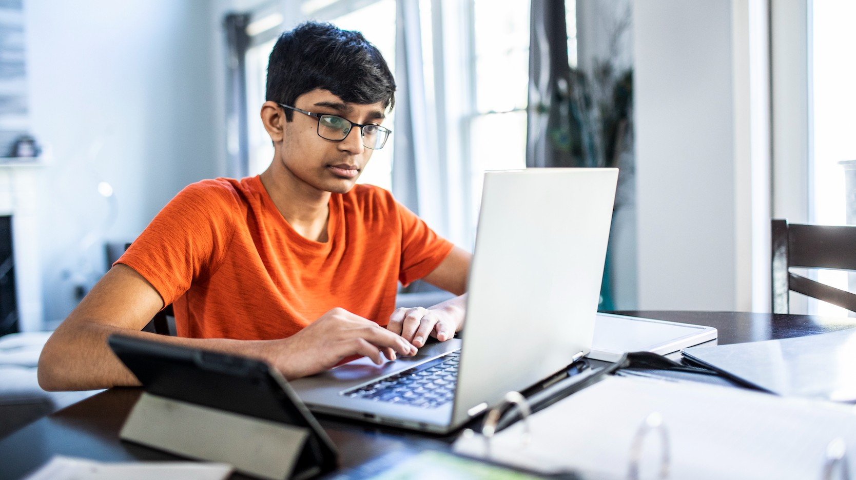 Student working on laptop at table