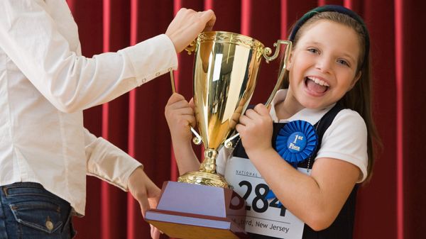 young student winning spelling bee trophy