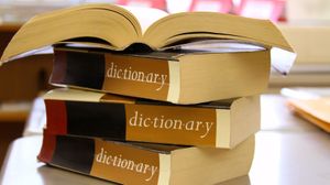 brown dictionaries stacked on table