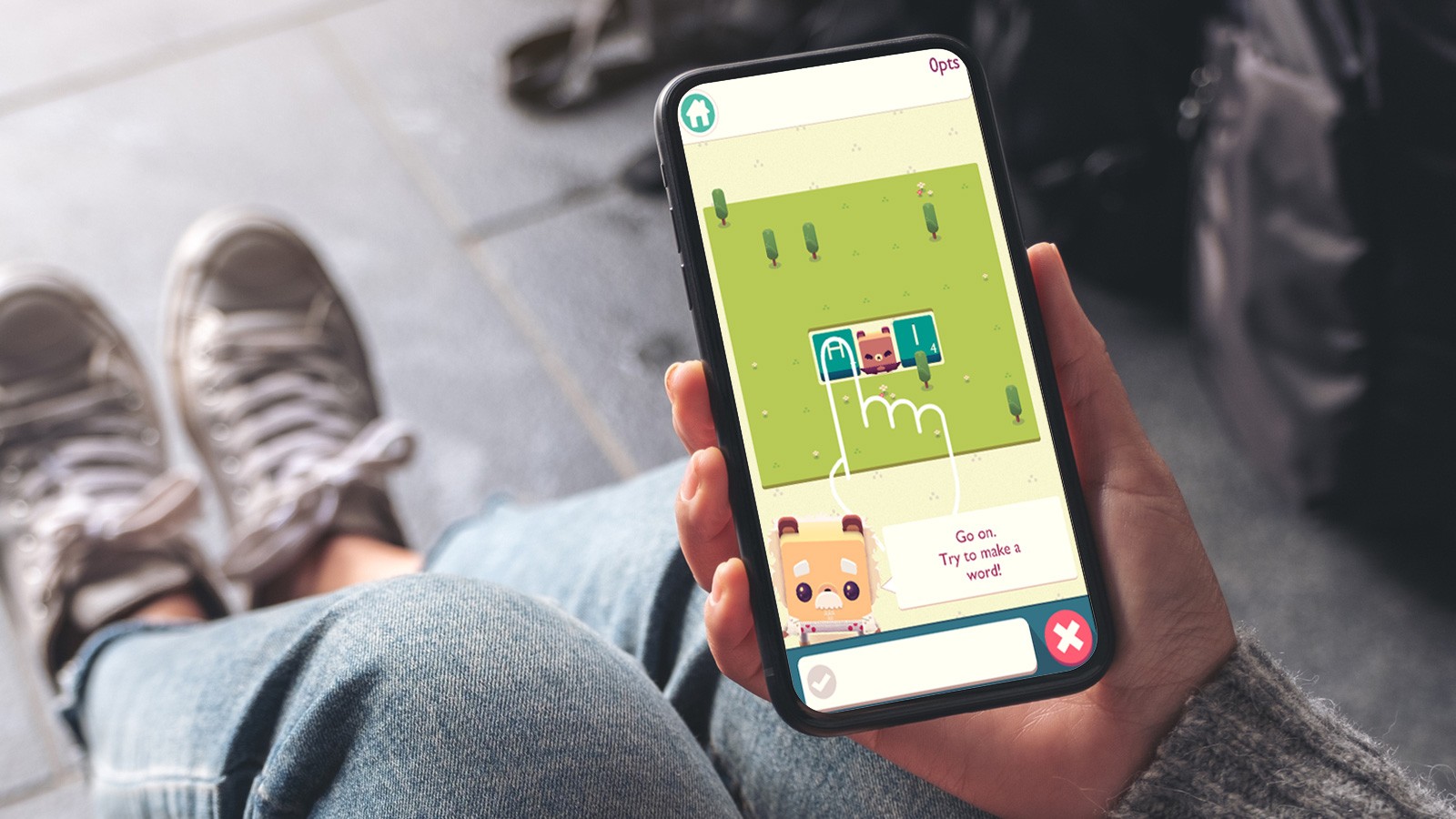 Girl playing alphabear2 game on phone