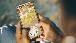 woman plays Wordscapes on her phone