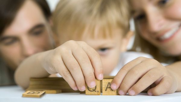 Boy arranging QA Scrabble letter tiles