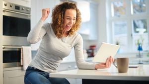 Happy woman playing game on tablet