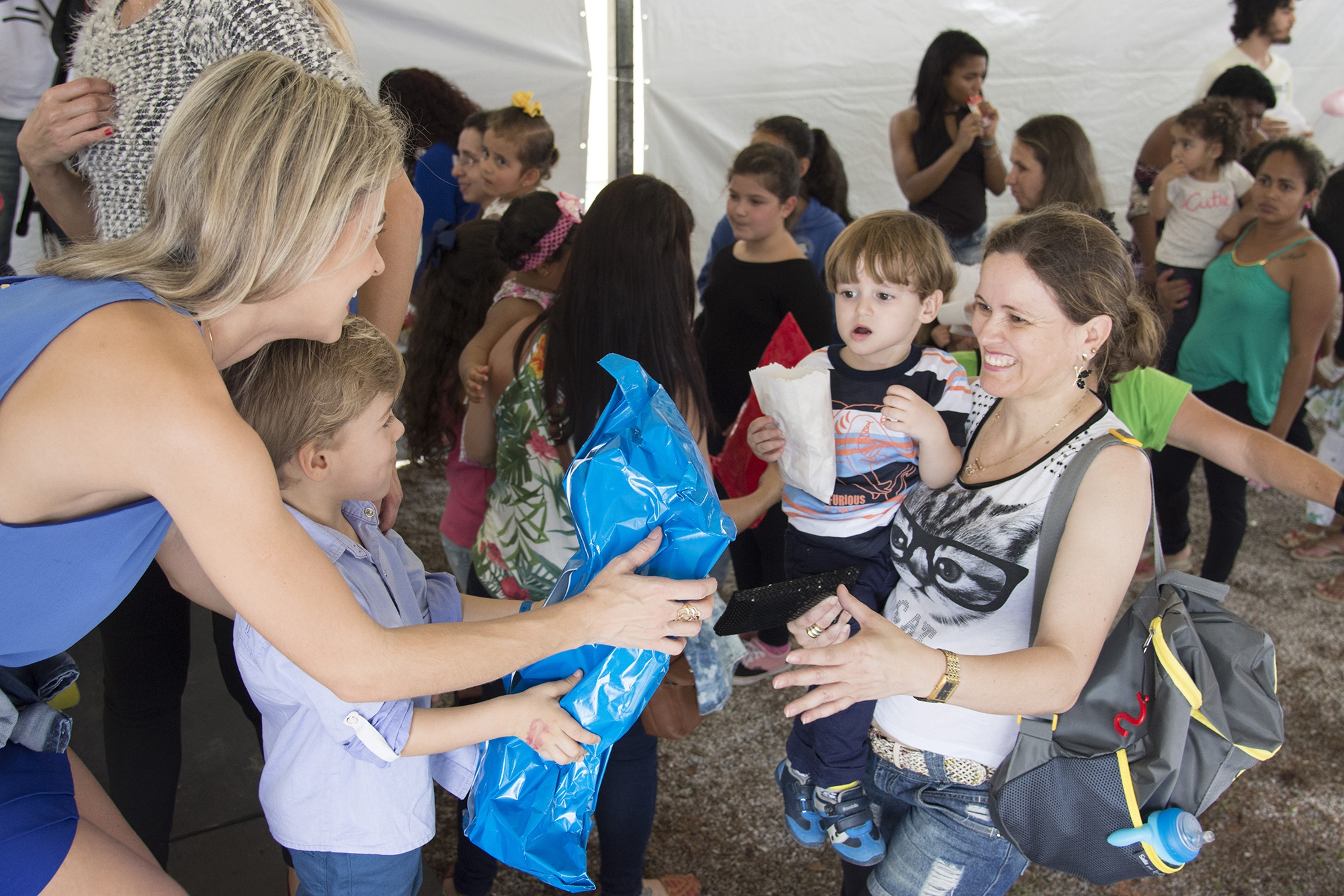 child handing wrapped package to another child; charitable leave donations; Photo by willian_2000