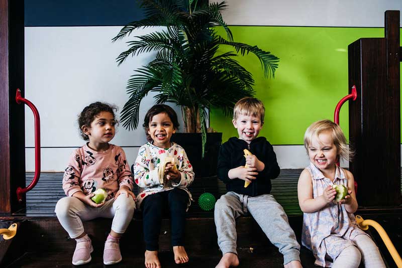 Older children enjoying fruit including banana a great choice for baby's first solid foods.