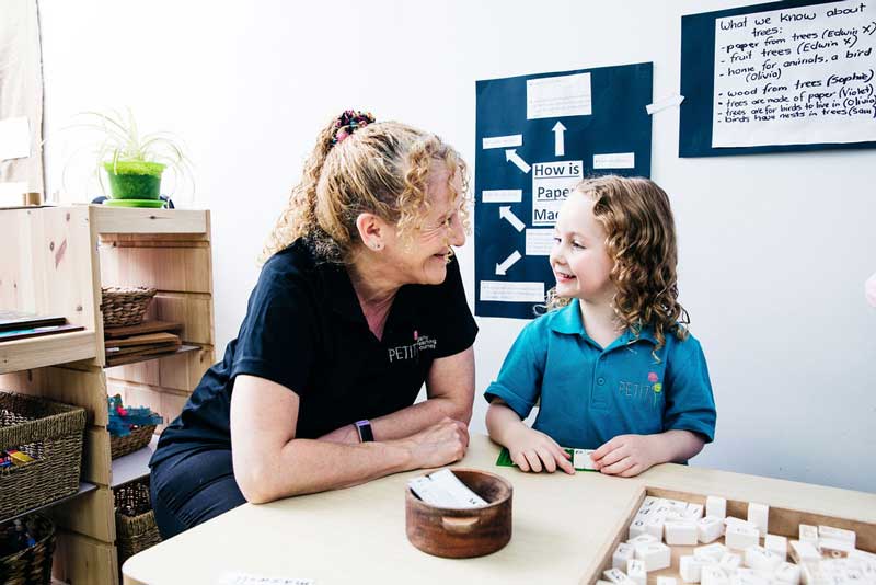 Educator and child engage in a eye contact game for teaching preschoolers conversational skills.