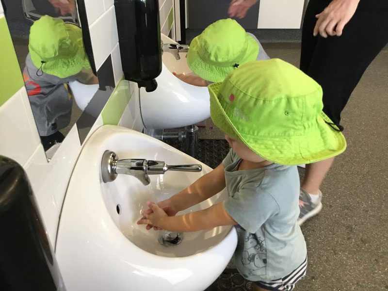 Children learn good hygiene habits like washing hands.