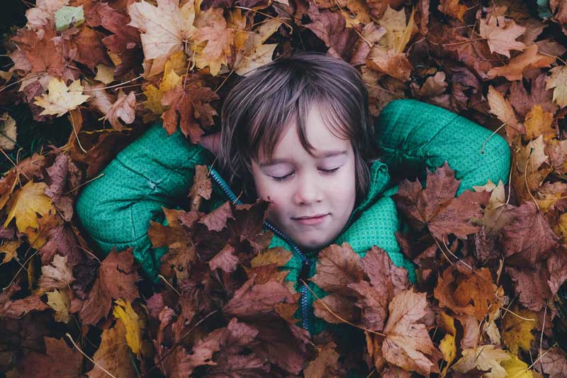 Boy practices mindful meditations for children outdoors in nature.