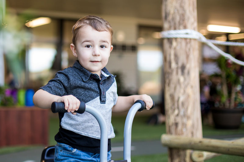 Child plays on a ride on toy as an active play activity.