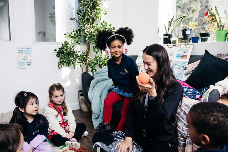 Educator teaches children good eating and hygiene practices in child care.