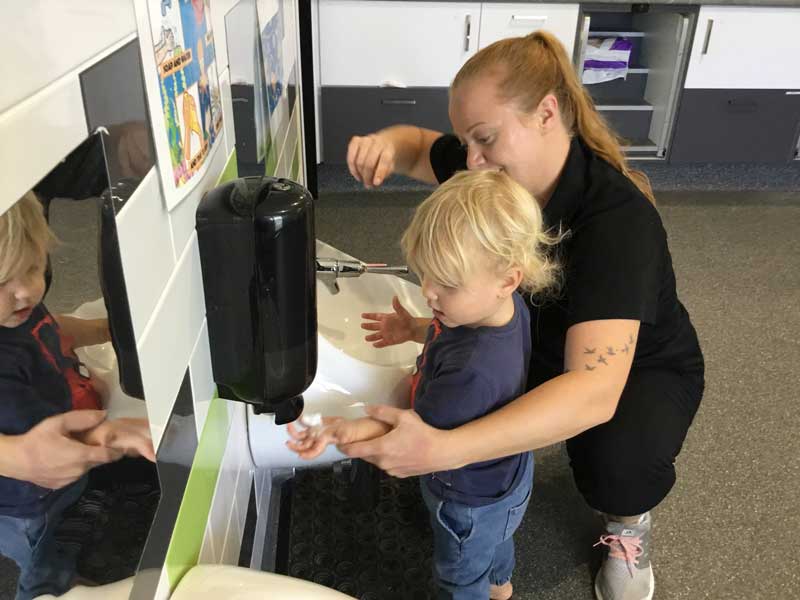 Child learns to wash hands as part of their toilet training steps.