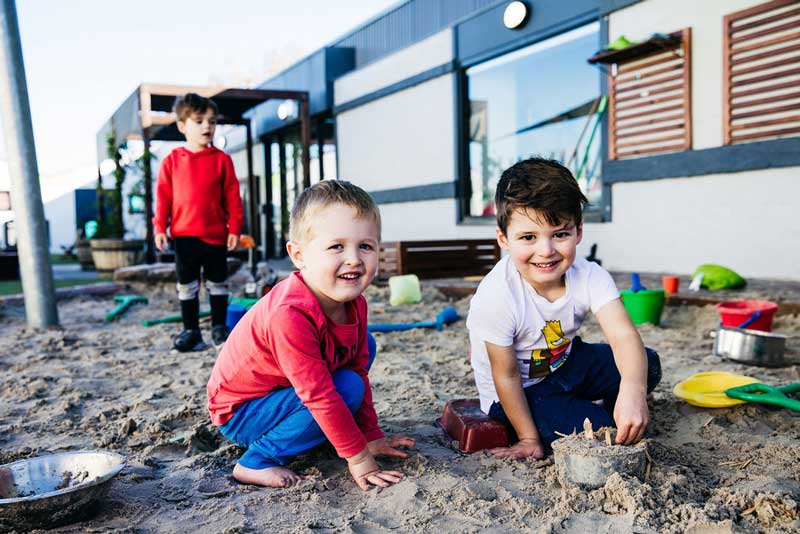 Children play in sand kitchen with items donated by building community connections for families.