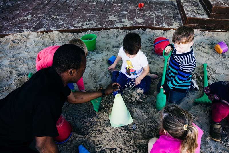 Educator gets down to children’s level to communicate while advocating for children’s rights and choices.