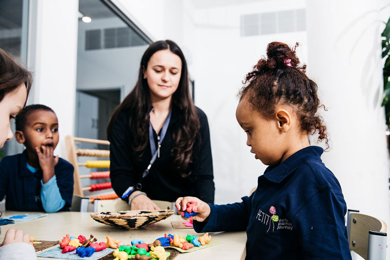 Preschoolers develop literacy skills with an early childhood teacher at Petit ELJ.