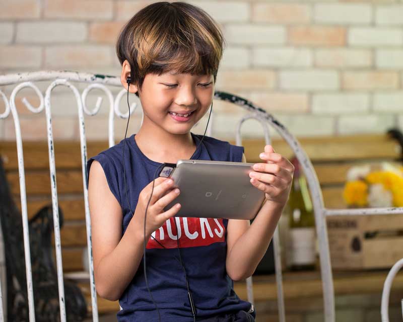 Child uses headphones with ipad and the best apps for 4-year-olds.