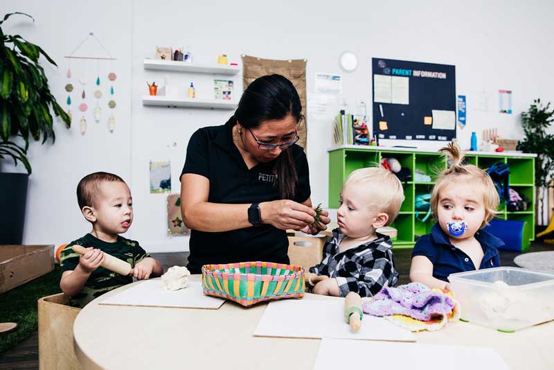 Educator helps infants with new concepts using different early childhood teaching approaches