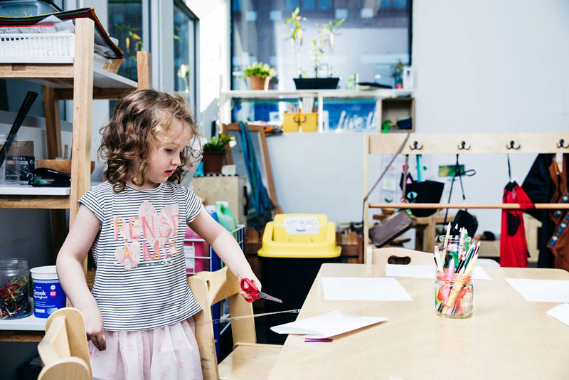 Child uses scissors for Christmas ideas and crafts encouraging the use of fine motor skills.