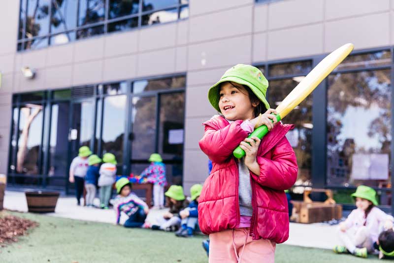 Child with soft cricket bat and ball in outdoor fun for kids