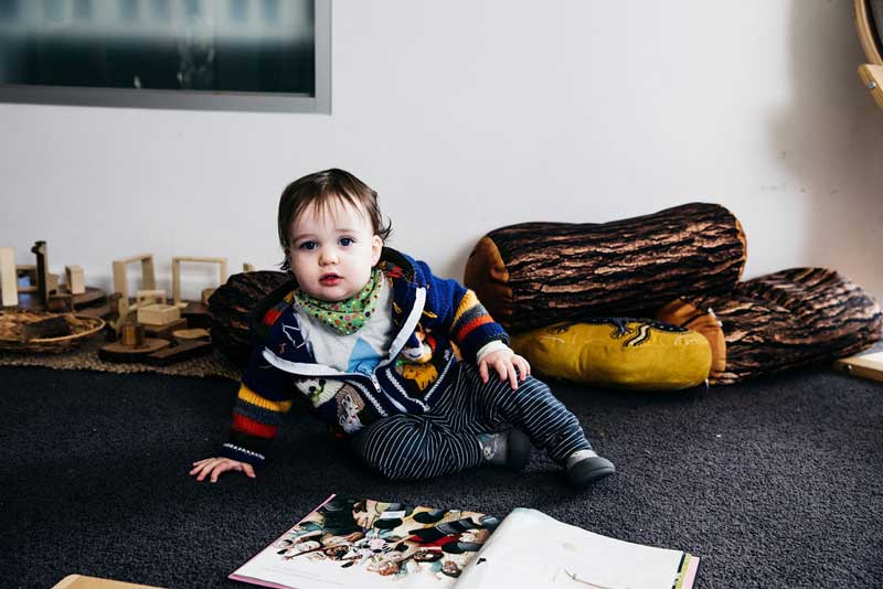 Child plays with a book to teach a child to read.