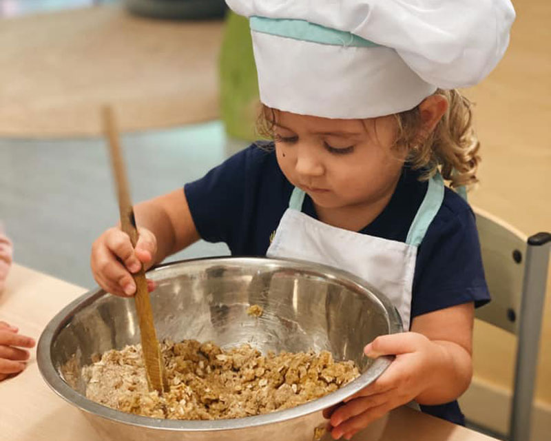 Child makes Anzac Day cookies as part of an Anzac Day activity.