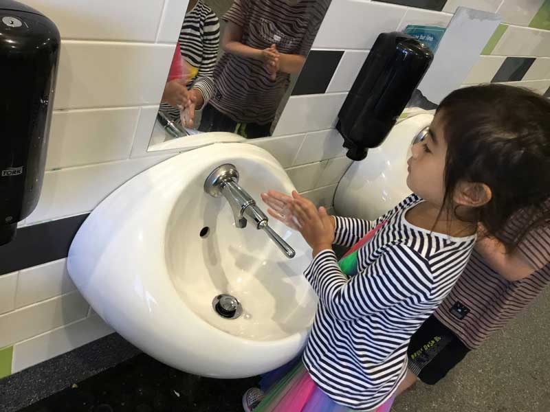 Children learn how to wash their hands to help stop the spread of infectious diseases.