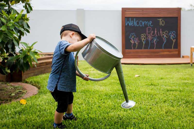 Child waters the grass - just one of the things to do on a rainy day.