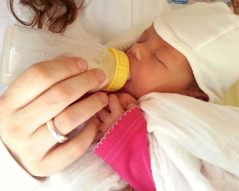 Mum takes a break from breastfeeding to practice expressing milk for work.