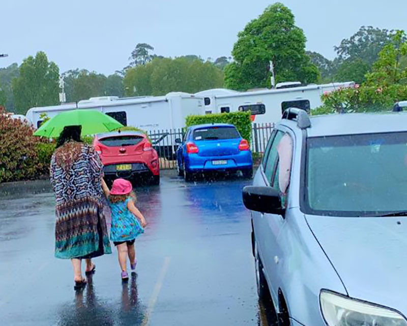 Travelling with children in a car may require umbrellas for rainy adventures.