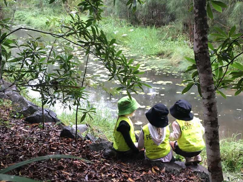 Children enjoy nature play while collecting natural materials.