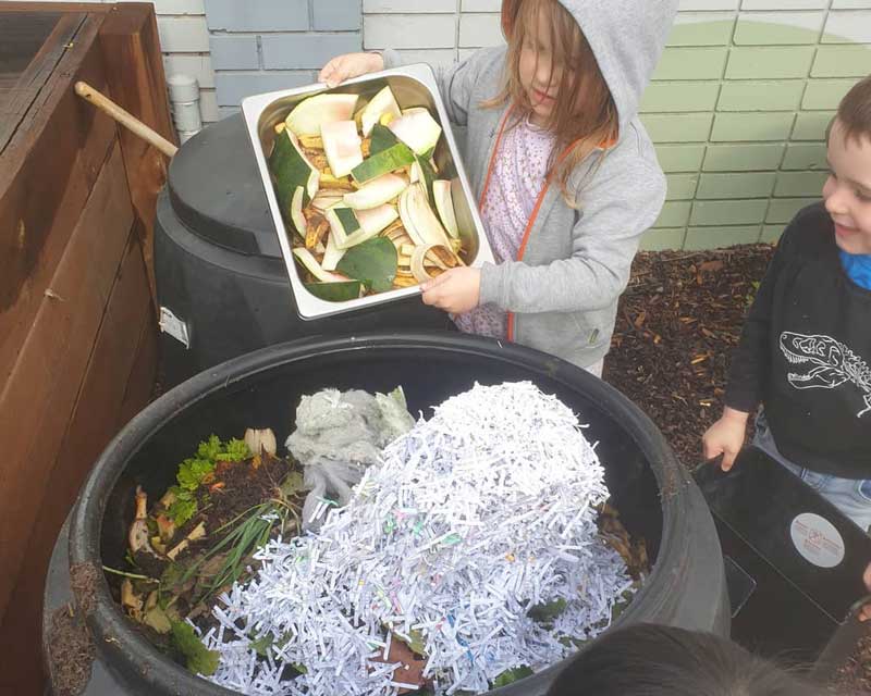 Children engage in composting, one of several Earth Day activities for toddlers.