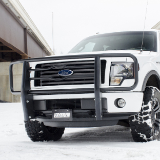 White Ford F150 with a black grille guard from LUVERNE in the snow