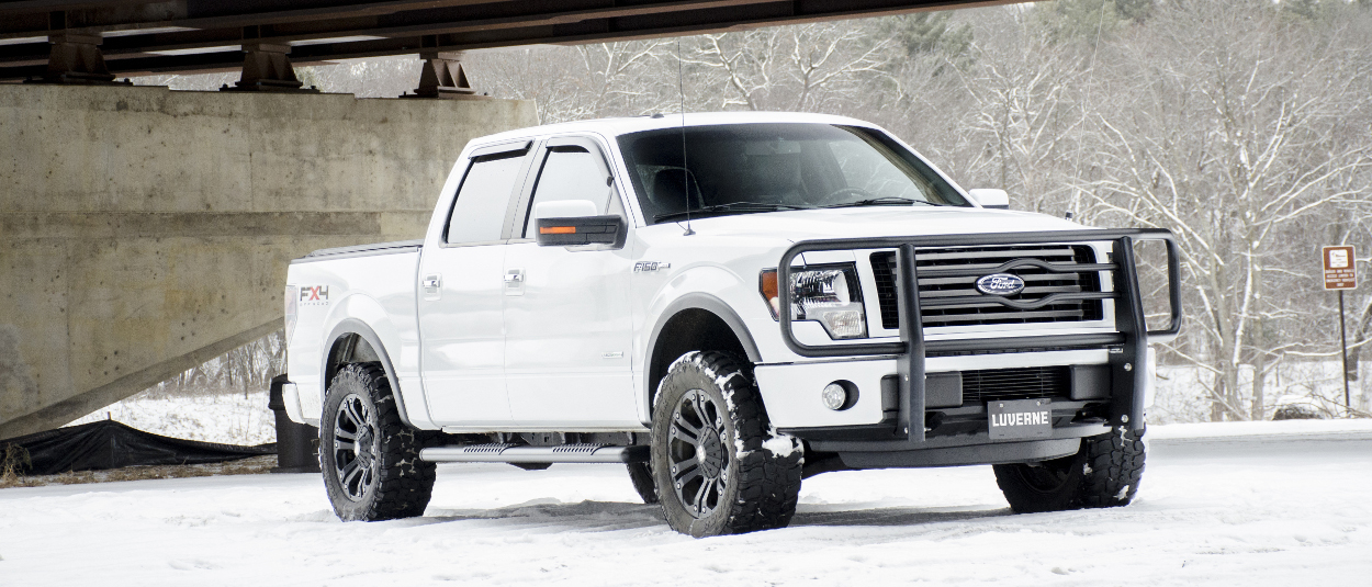 White Ford F150 in the snow with a black LUVERNE grille guard