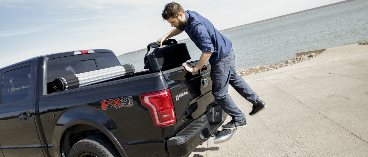 LUVERNE hitch step on black 2016 Ford F150 - man loading cargo