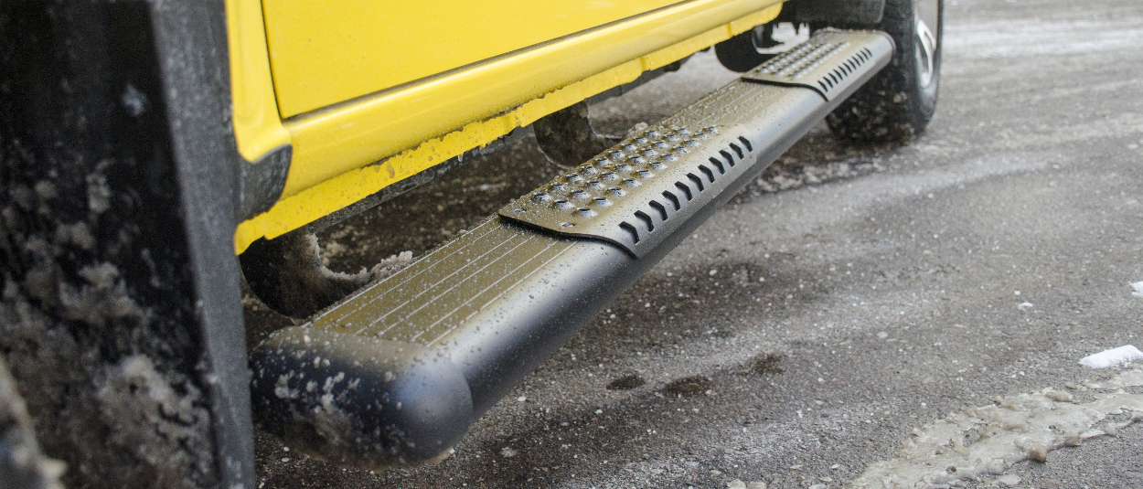 LUVERNE O Mega II™ side steps on a yellow truck in the snow