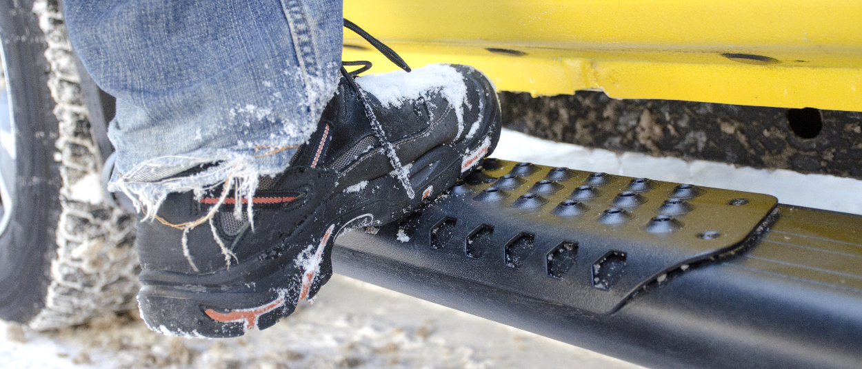 O-Mega II™ aluminum side steps with work boots in the snow