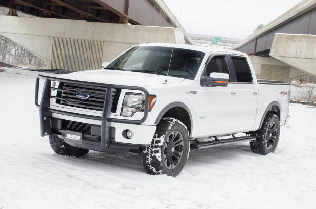 White Ford F150 in the snow with O-Mega II™ side steps and brush guard