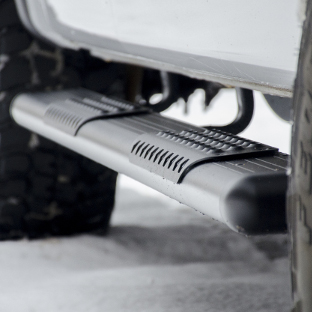 White truck in snow with black aluminum O-Mega II™ side steps