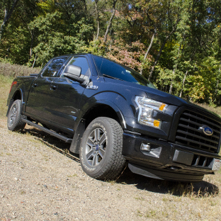 Black Ford F150 with SlimGrip™ running boards in the forest