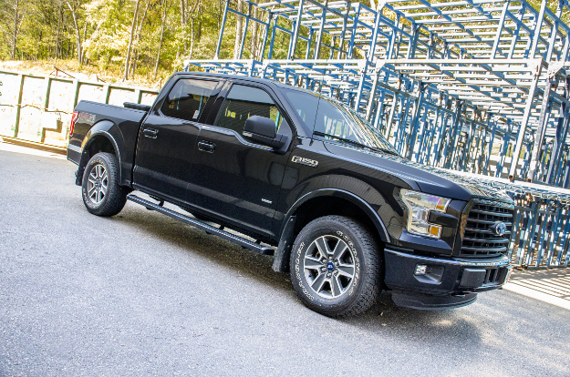 Black Ford F150 with SlimGrip™ running boards by power station