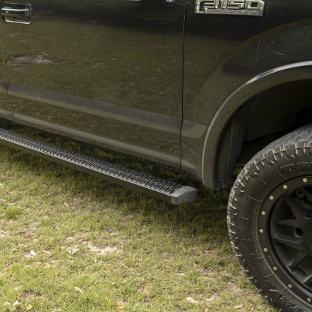 LUVERNE SlimGrip™ running boards on black Ford F150 on the grass