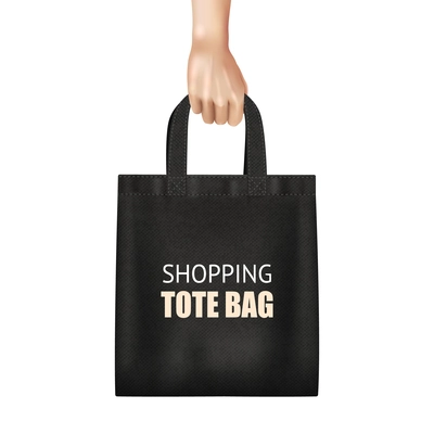 Hand holding fashionable black canvas shopping tote bag with lettering realistic close up view vector illustration