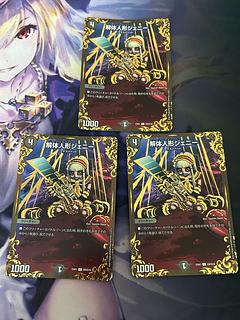 three flat objects (e.g. tickets, pieces of cloth, etc.) Deconstruct doll Jenny (Ultra Golden Card Spec.) C-foil G9/G10