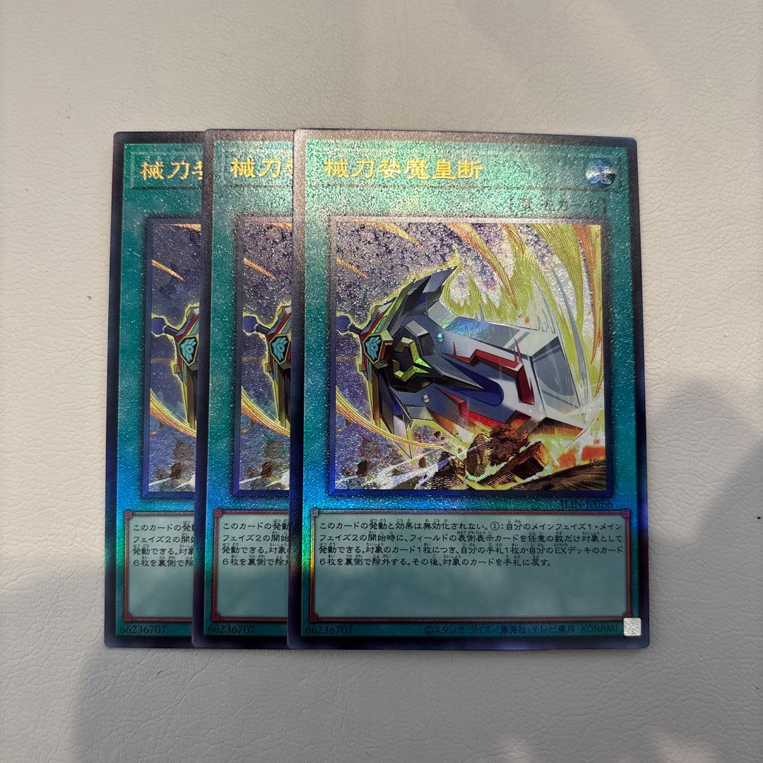 three flat objects (e.g. tickets, pieces of cloth, etc.) 械刀婪魔皇断 Ultimate Rare ALIN-JP066