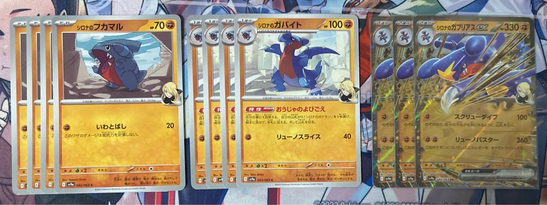 three flat objects (e.g. tickets, pieces of cloth, etc.) Cynthia's Garchompex RR 044/063